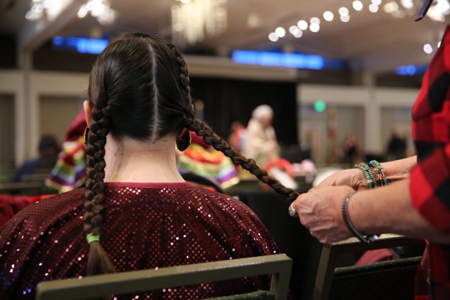 Diane Yankton braids her granddaughter, Morning Star Yazzie's, hair at the 36th annual AISES Pow Wow at the LSC on Nov. 3, 2018. (Forrest Czarnecki | Collegian)