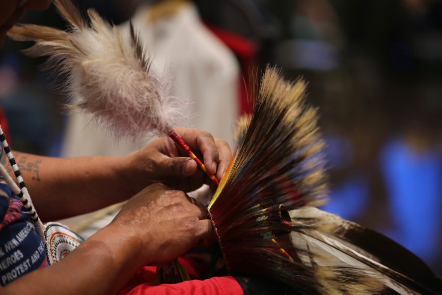 Gerald Montour prepares his regalia at the 36th annual AISES Pow Wow at the LSC on Nov. 3, 2018. The regalia that Montour was putting the finishing touches on was made of a deer tail, porcupine hair and eagle feathers.(Forrest Czarnecki | Collegian)