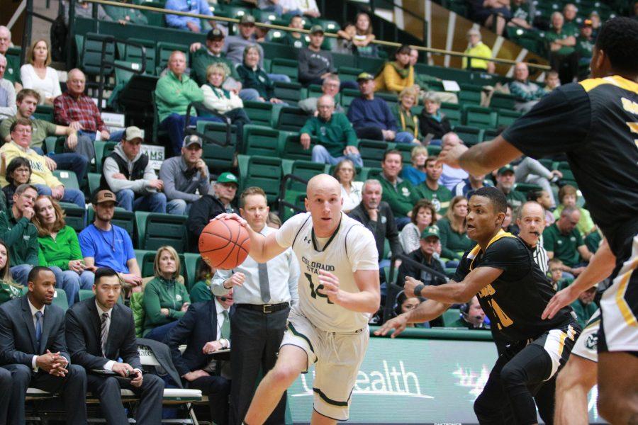 Robbie Berwick (14) drives towards the basket while being defended by a UAPB player. The Rams defeat UAPB 92-67. (Devin Cornelius | Collegian)