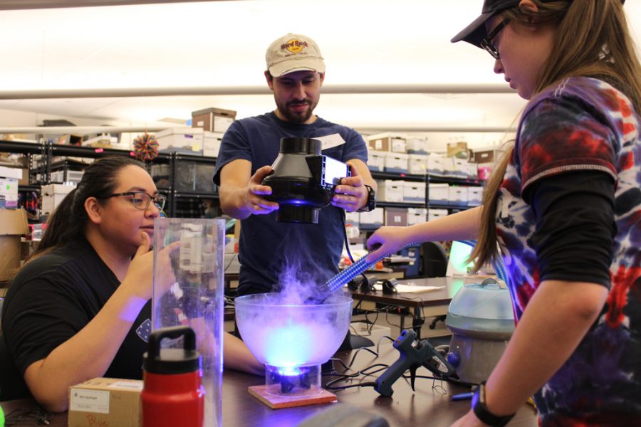 Erica Lafferty, Jake Ferguson and Alexandra Smith work on one of the lessons for the 4th-8th graders at the Little Shop of Physics event on Dec. 8. (Joshua Contreras | Collegian).