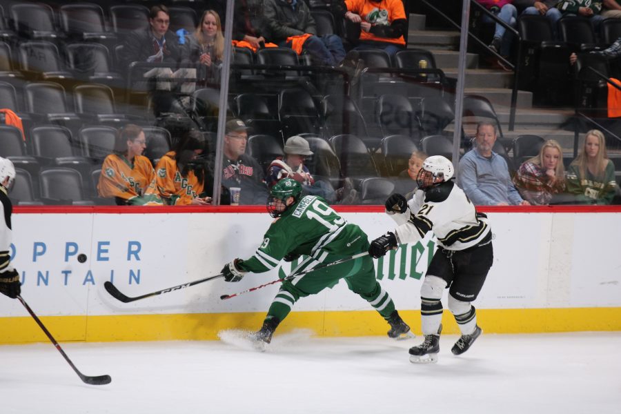 Aksel Campbell (19) passes the puck to a teammate while being guarded by a CU player during CSU's game against CU. The Rams win 8-3 (Devin Cornelius | Collegian)