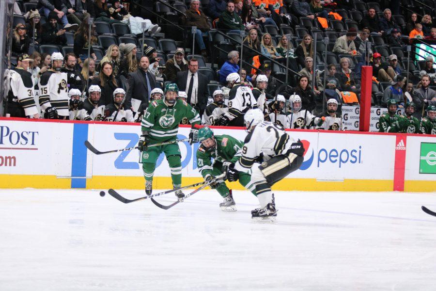 Ben Joseph (21) passes the puck down the ice after a pass from Christopher Nitchen (17) as the Rams battle the Buffs. The Rams fall to the Buffs 8-3.,(Devin Cornelius | Collegian)
