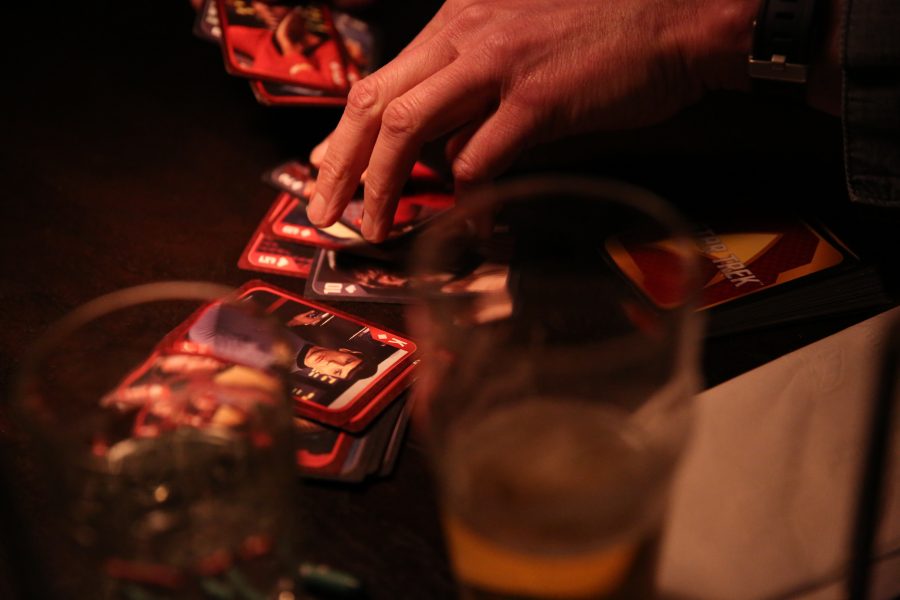 Rudy Schuster, right, and his twin daughters Claudia, left, and Anya, middle, play a game of cards while waiting for their food at Nick's Italian restaurant on Jan. 23. Schuster is employed by the United States Geologic Survey, but has been unable to work due to the federal government shutdown. Nick's was holding an event where federal employees could receive a free meal with a valid government ID. (Forrest Czarnecki | Collegian)