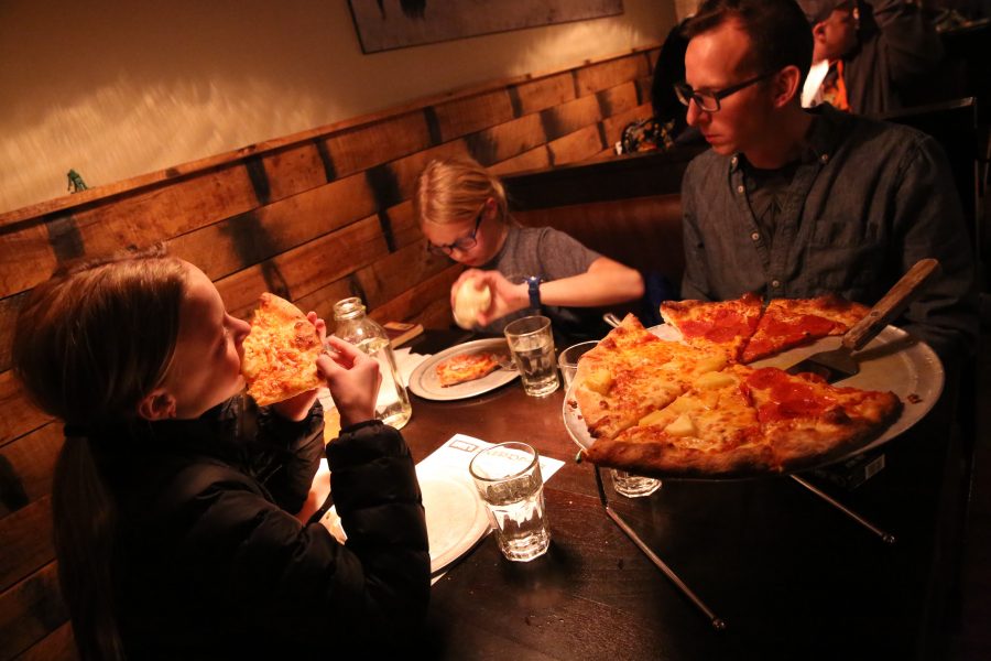Rudy Schuster, right, and his twin daughters Claudia, left, and Anya, middle, have dinner at Nick's Italian restaurant on Jan. 23. Schuster is employed by the United States Geologic Survey, but has been unable to work due to the federal government shutdown. Nick's was holding an event where federal employees could receive a free meal with a valid government ID. (Forrest Czarnecki | Collegian)