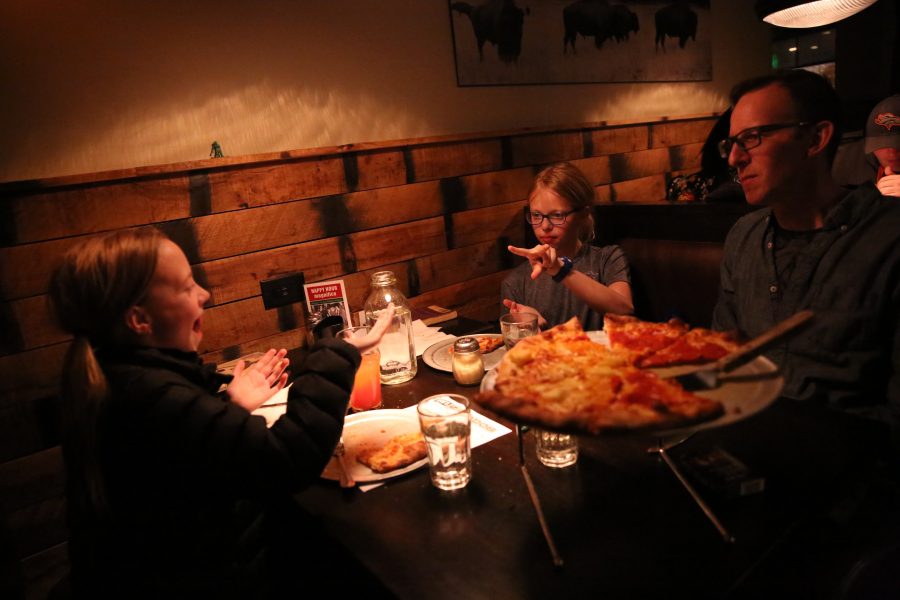 Rudy Schuster, right, watches while his twin daughters Claudia, left, and Anya, middle, play a game of rock, paper, scissors over dinner at Nick's Italian restaurant on Jan. 23. Schuster is employed by the United States Geologic Survey, but has been unable to work due to the federal government shutdown. Nick's was holding an event where federal employees could receive a free meal with a valid government ID. (Forrest Czarnecki | Collegian)
