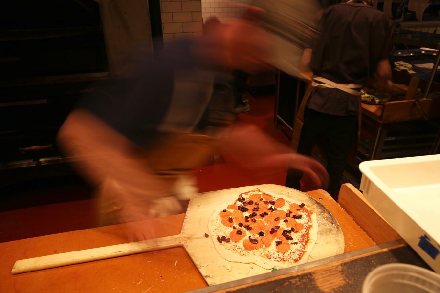 Brian Shaner adds the finishing touches to a pizza at Nick's Italian restaurant on Jan. 23. Nick's was holding an event where federal employees could receive a free meal with a valid government ID. (Forrest Czarnecki | Collegian)