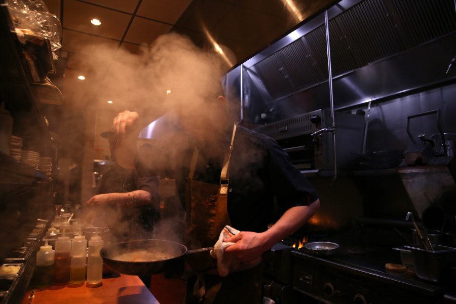 Nicholas Lobato, a line cook at Nick's Italian restaurant, works behind a cloud of steam and puts the finishing touches on a meal on the night of Jan. 23. Nick's was holding an event where federal employees could receive a free meal with a valid government ID. (Forrest Czarnecki | Collegian)