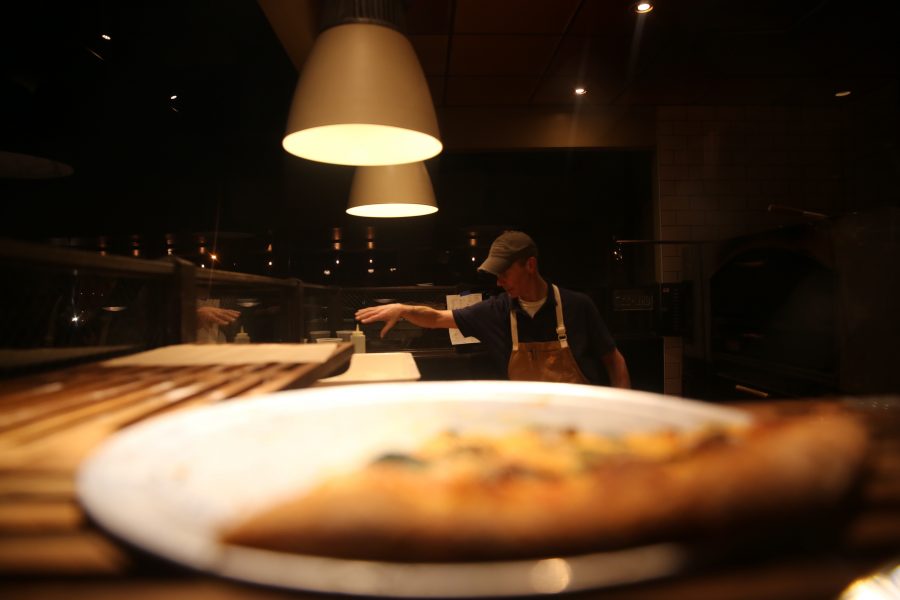 Brian Shaner adds the finishing touches to a pizza at Nick's Italian restaurant on Jan. 23. Nick's was holding an event where federal employees could receive a free meal with a valid government ID. (Forrest Czarnecki | Collegian)
