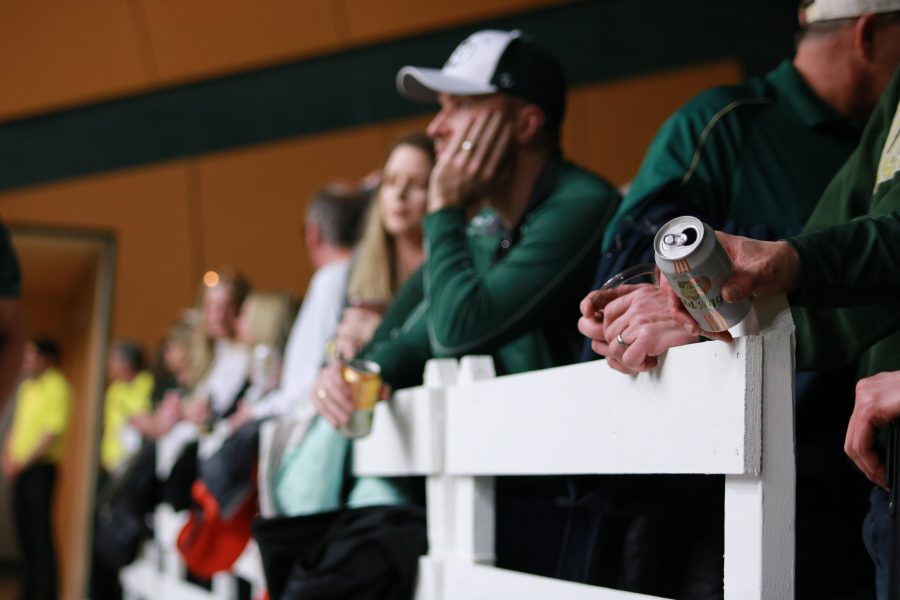 A fan holds an Old Aggie can while watching a Colorado State Basketball game.