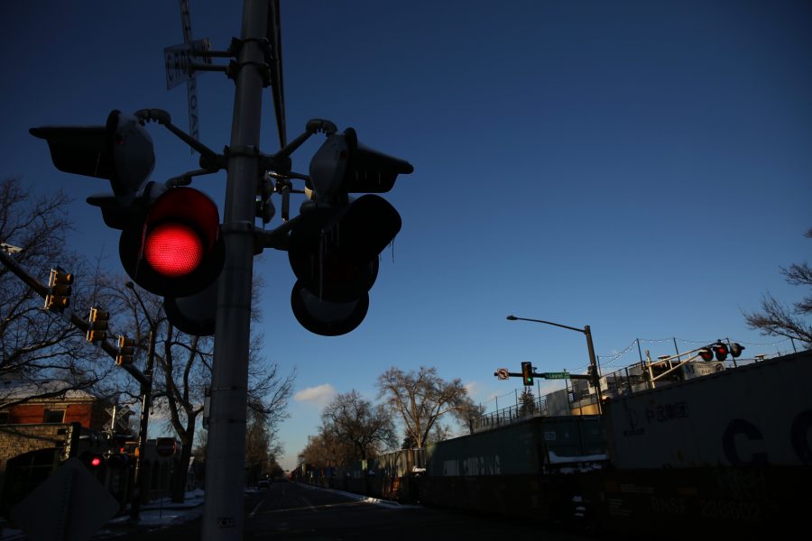 Railroad crossing lights flash while a freight train is stopped near the intersection of Mason and Laurel streets following a collision with a pedestrian at approximately 2:57 p.m. Feb. 7. One fatality was confirmed by Fort Collins Police Services. (Forrest Czarnecki | Collegian)