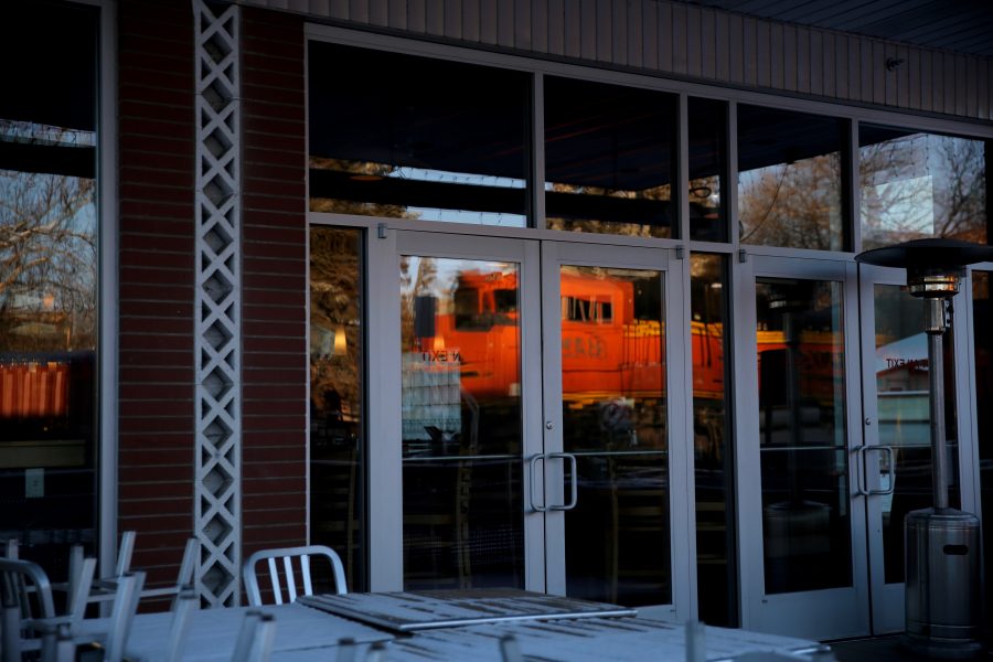 A stopped freight train is reflected in the windows of a storefront near the intersection of Mason and Laurel streets following a train and pedestrian collision at approximately 2:57 p.m. Feb. 7. One fatality was confirmed by Fort Collins Police Services. (Forrest Czarnecki | Collegian)