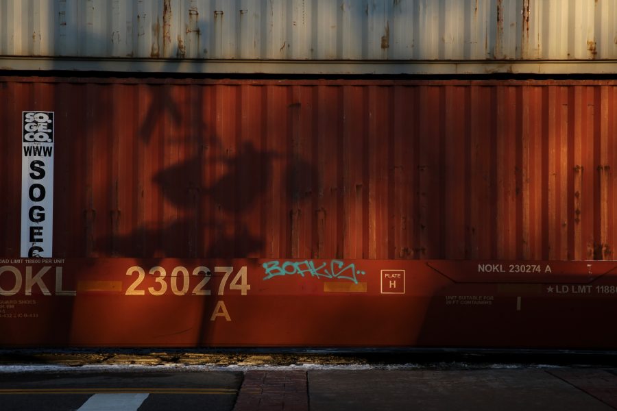 The shadows of a railroad crossing sign are seen on the car of a stopped freight train near the intersection of Mason and Mulberry streets following a train and pedestrian collision at approximately 2:57 p.m. Feb. 7. One fatality was confirmed by Fort Collins Police Services. (Forrest Czarnecki | Collegian)