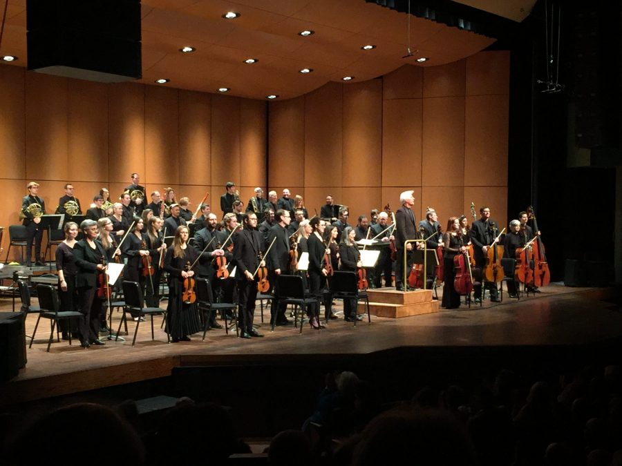 Wes Kenney and the Fort Collins Symphony stand for applause at the end of their performance. Shot by Lyra Wiley.