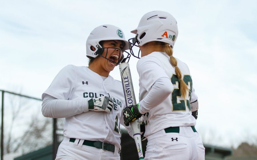 Isabella Navarro celebrates with Jordan Acosta after scoring a run after her teammate hit a home run with two players on base during the first Colorado State Classic March 1. The Rams won all three games they were able to play during the Classic. (Ashley Potts | Collegian)