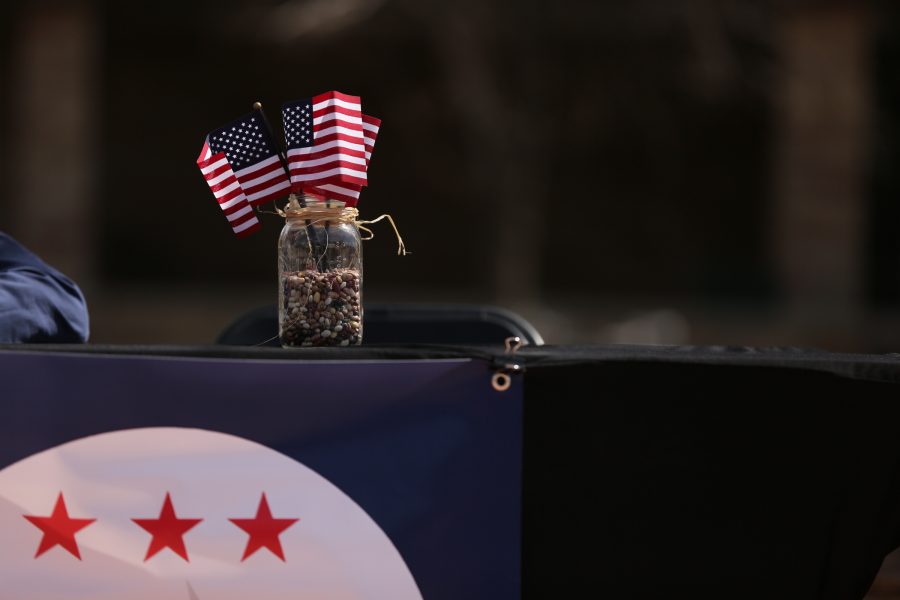 Miniature American flags and political signs hang from Josh Johnson's table during the ASCSU president and vice president election debate in the Plaza March 27. (Forrest Czarnecki | Collegian)