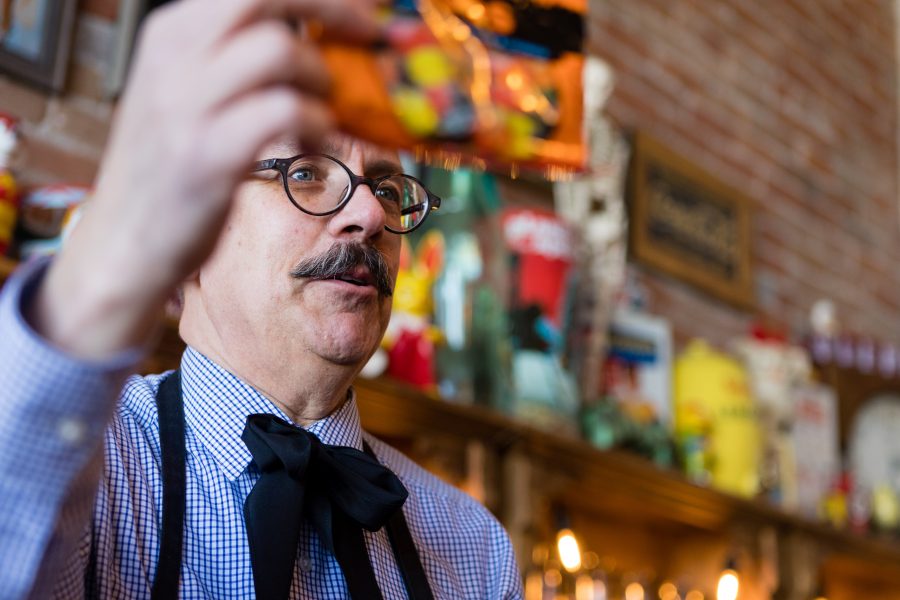 Tony Vallejos, owner of The Fort Collins Candy Store Emporium, holds up a bag of his favorite candy inside his quirky, old-school shop. Originally from California, Vallejos is a retired interior designer who pursued his childhood dream of opening a candy store. His favorite candies are Licorice Duos, a chewy piece of licorice mixed with a fruit gummy. (Brooke Buchan | Collegian). 