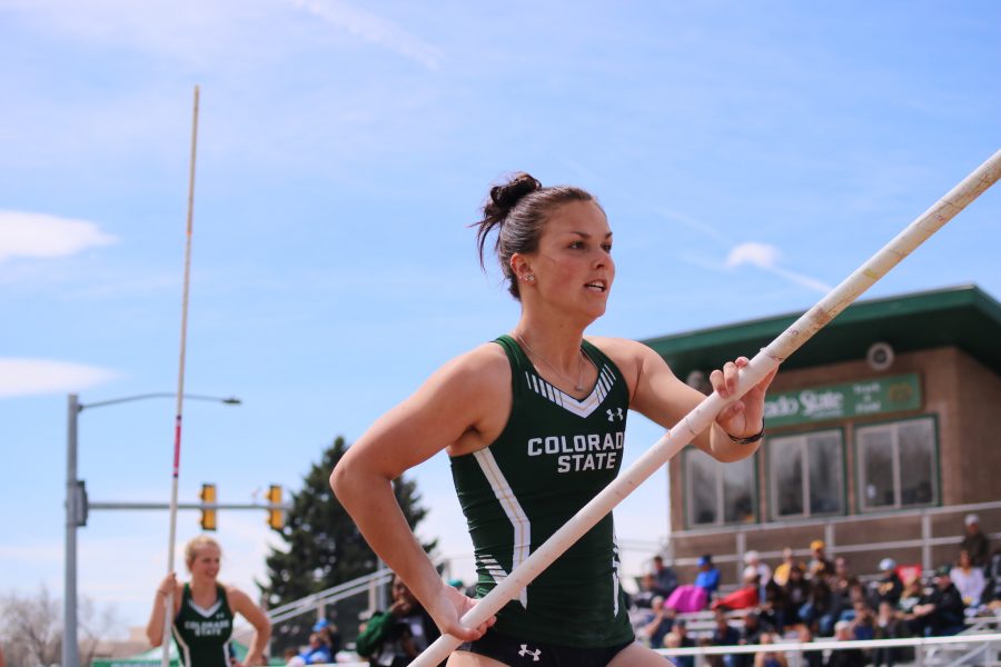 Josie Spitz runs towards the pole vaulting mat while her teammate and the crowd look on, at the Doug Max Invitational. (Devin Cornelius | Collegian)