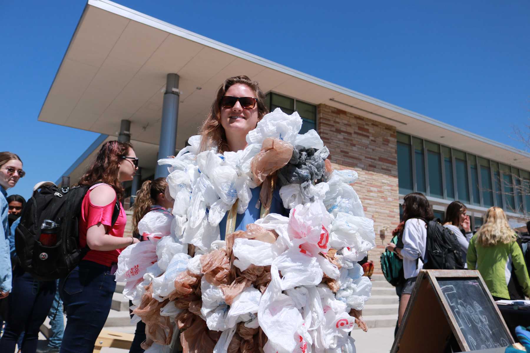 CSU Student smiles while wearing plastic bags