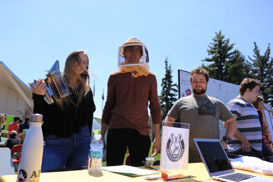 Shannon Kinsella, Freddie Haberecht, and Nolan Bunting pose for the camera while working a booth about bees at the CSU Earth Day Celebration.  Freddie said that "Bees are great ambassadors for the environment". (Devin Cornelius | Collegian)