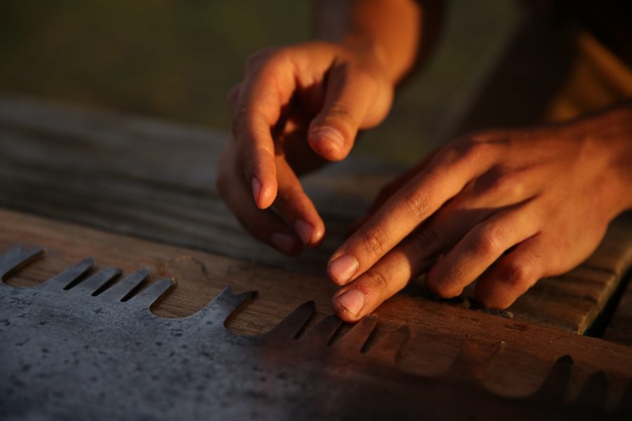 Galen Burr applies WD-40 to the teeth of a crosscut saw following on the Colorado State University logging team's practices. (Forrest Czarnecki | College Avenue)