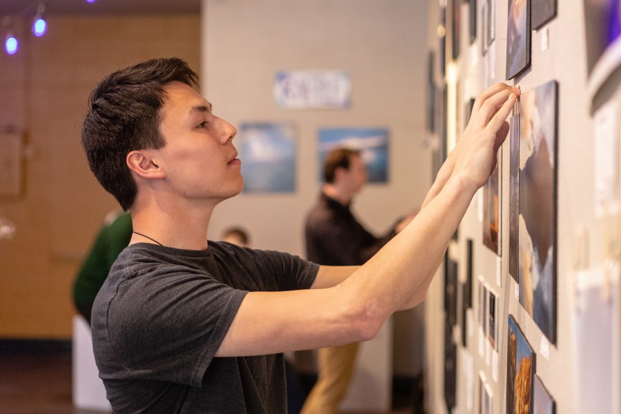 Senior microbiology major Bryan Bennis carefully mounts one of the photos in his gallery inside the Art Lab Friday afternoon. Bennis is part of the Colorado State University Photography Club, who hosted the student photography exhibition as a way for members to showcase and sell their work. "I love to get up early and watch the sun rise on the mountains. If I didn't get into photography I know I wouldn’t go to as many beautiful places in Colorado. It makes me excited to go out and explore." (Brooke Buchan | Collegian)