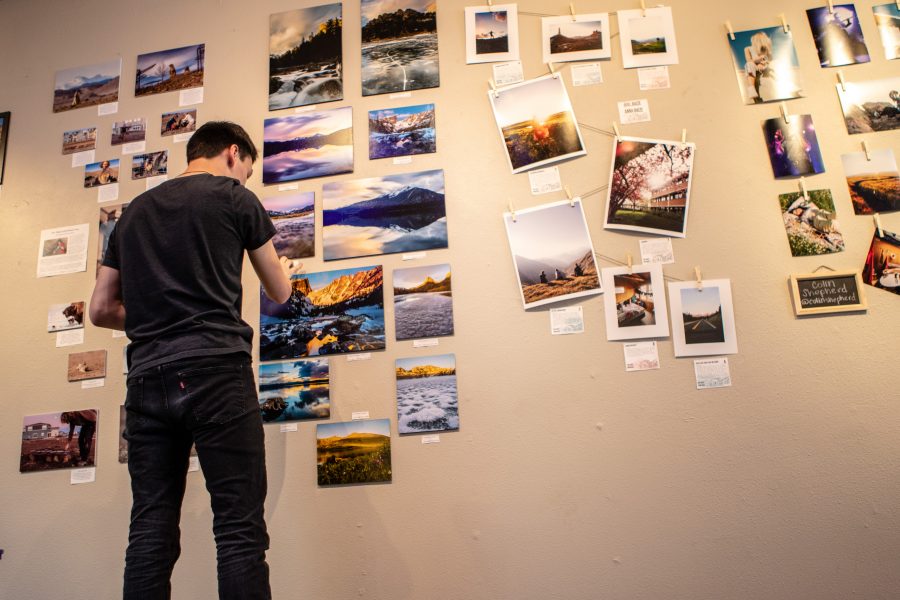 Senior microbiology major Bryan Bennis carefully mounts one of the photos in his gallery inside the Art Lab Friday afternoon. Bennis is part of the Colorado State University Photography Club, who hosted the student photography exhibition as a way for members to showcase and sell their work. "I love to get up early and watch the sun rise on the mountains. If I didn't get into photography I know I wouldn’t go to as many beautiful places in Colorado. It makes me excited to go out and explore." (Brooke Buchan | Collegian)