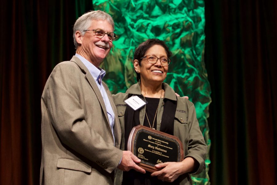 Dan Bush gives Mary Ontiveros the Oliver P. Pennock Distinguished Service Award in the LSC Grand Ballroom. The Celebrate! Colorado State Awards focused on recognizing a wide variety of CSU faculty, staff and students for their service and many accomplishments. (Ryan Schmidt | Collegian)
