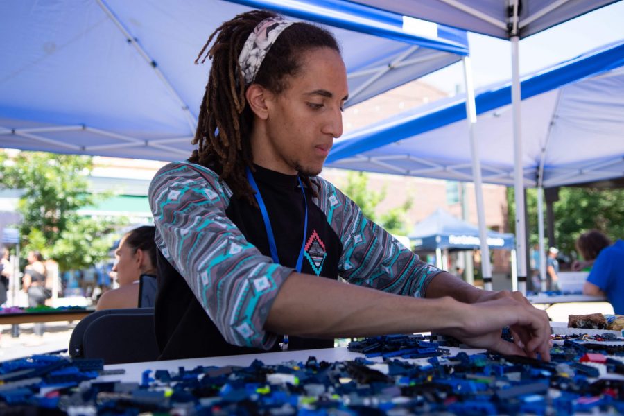 LEGO Artist Osi Ogbuji, begins work on his futuristic vision of the city of Boulder and the Flatiorns at the first LEGO Creation Festival held by the Downtown Development Authority on July 20. Ogbuji placed 2nd with his piece and found out about the competition through the Denver LEGO Users Group. (Matt Tackett | Collegian)