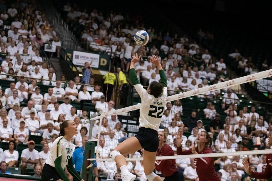 Katie Oleksak (22) sets Paulina Hougaard-Jensen (11), during their home whiteout match against OU. The Rams beat the Sooners  three sets to zero. (Devin Cornelius | Collegian)