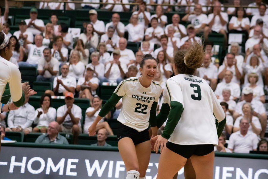 Katie Oleksak (22) and Olivia Nicholson (3) celebrate a score as the Rams take on the Sooners, during a whiteout home game. CSU wins three sets to zero. (Devin Cornelius | Collegian)