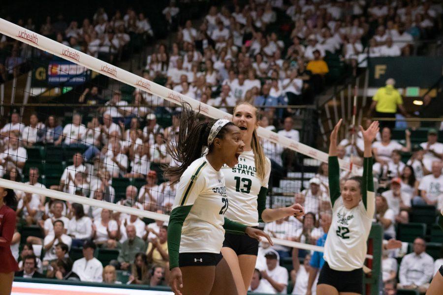 Jessica Jackson (21), Kirstie Hillyer (13) and Katie Oleksak (22) celebrate after a big score by Jackson, during the home whiteout game vs OU. CSU wins three sets to zero. (Devin Cornelius | Collegian)
