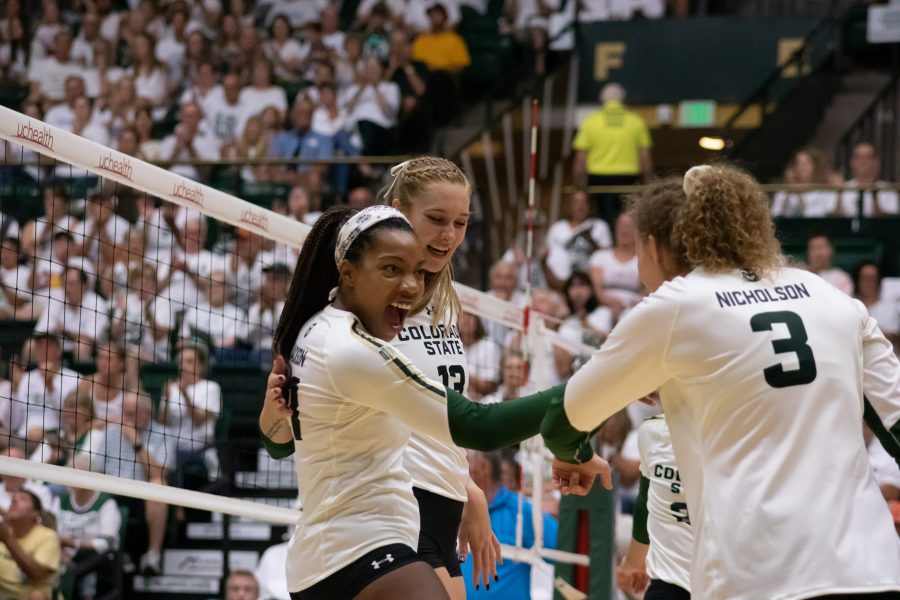 Jessica Jackson (21), Kirstie Hillyer (13) and Olivia Nicholson (3) celebrate after a big score by Jackson, during the home whiteout game vs OU. CSU wins three sets to zero. (Devin Cornelius | Collegian)