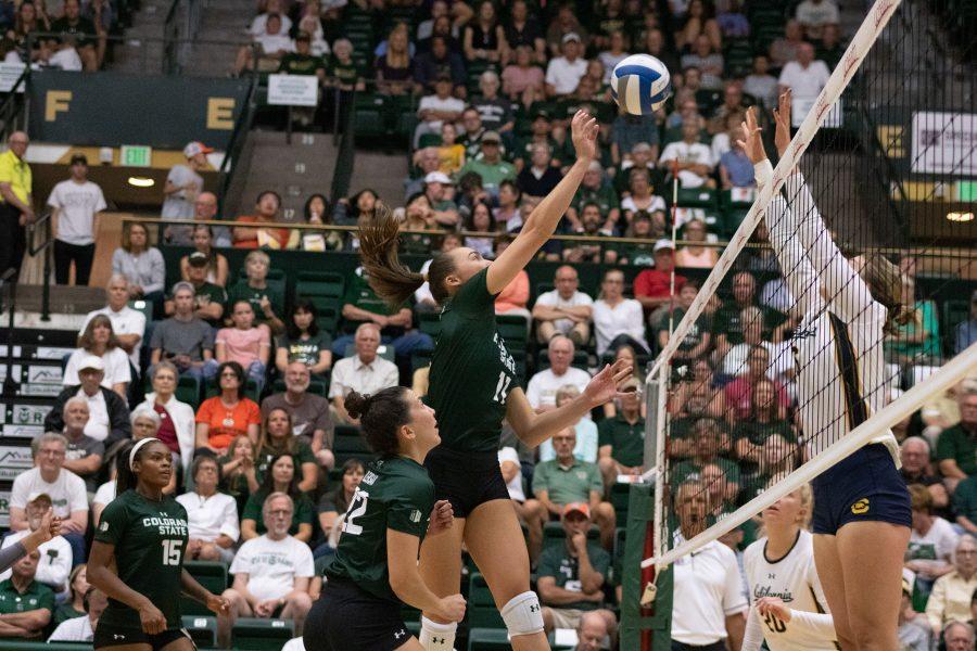 Paulina Hougaard-Jensen (11) taps the ball over defenders, during the CSU game against CAL Berkeley, at home. The Rams fall three sets to one. (Devin Cornelius | Collegian)