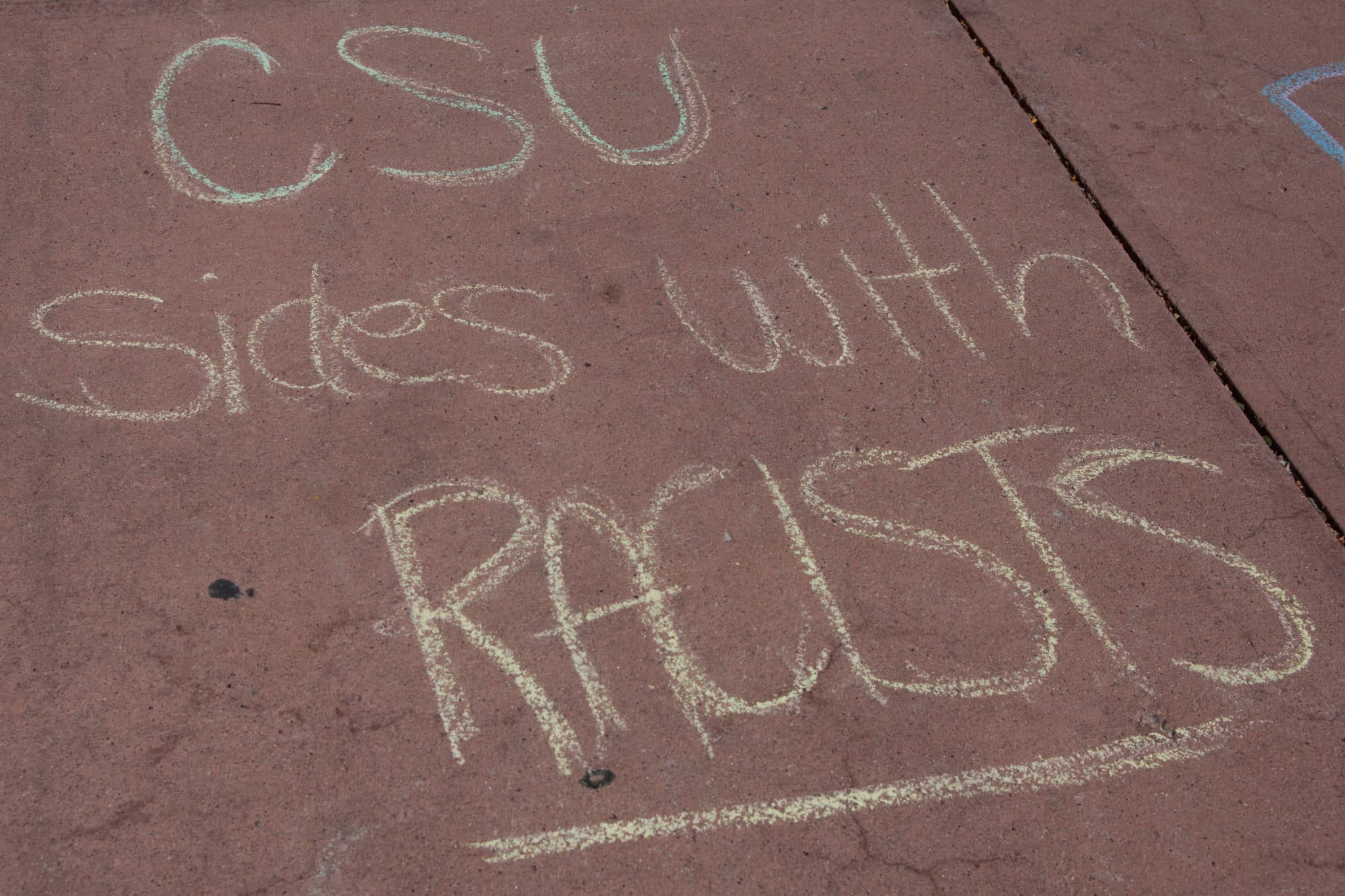 chalk message reading CSU sides with racists