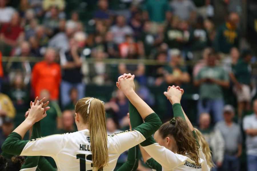 The Rams hold hands after winning a point against the UNC Bears. (Luke Bourland | Collegian)