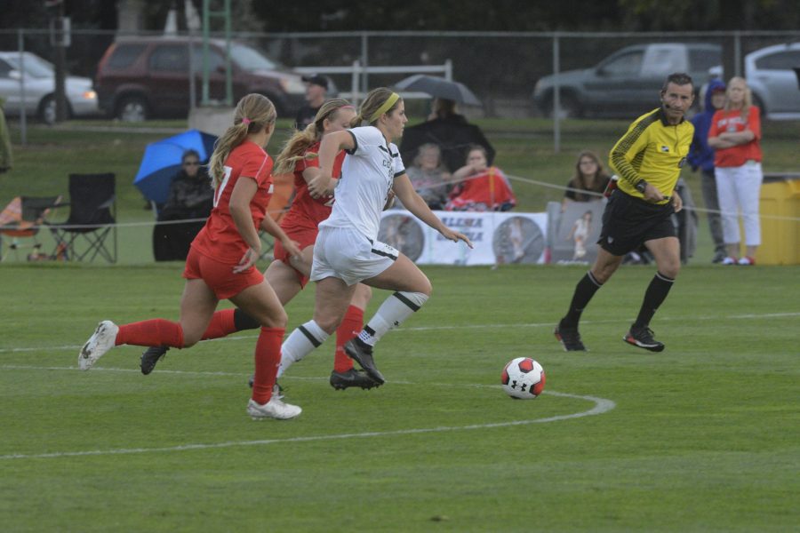 Senior midfielder Caeley Lordemann (14) dribbles the ball through two New Mexico defenders in the Rams 1-0 win over the visiting Lobos on Sept. 27. Lordemann had the game’s only goal in overtime to bring the Rams even with their previous record for wins in a season. (Gregory James | Collegian)