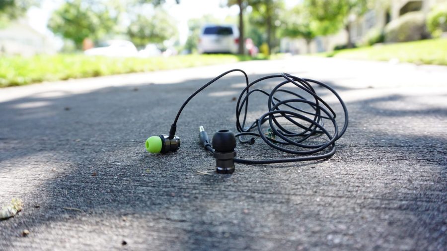 A pair of headphones cast aside onto the sidewalk. (Fynn Bailey | Collegian) 