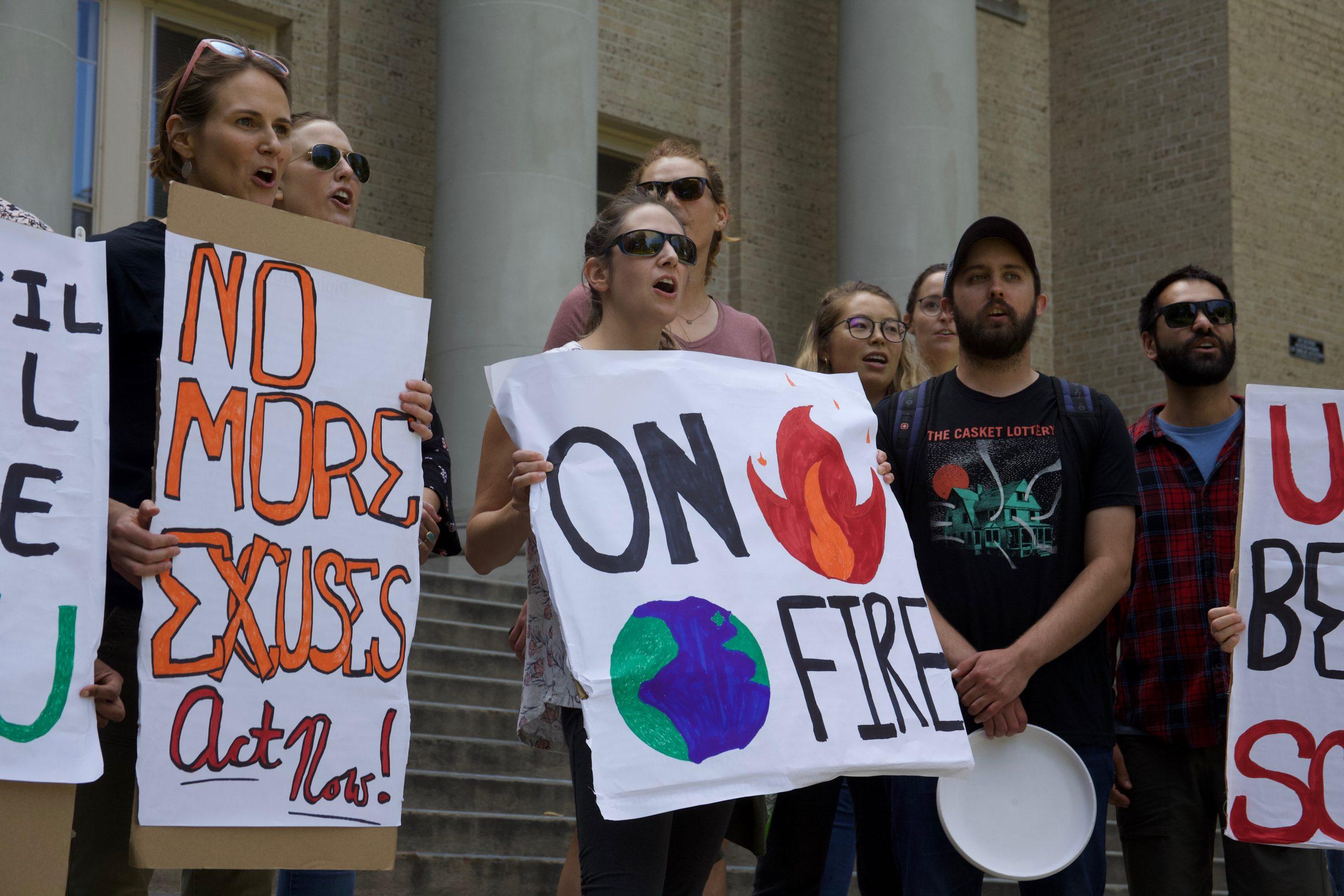 protesters with signs about global warming