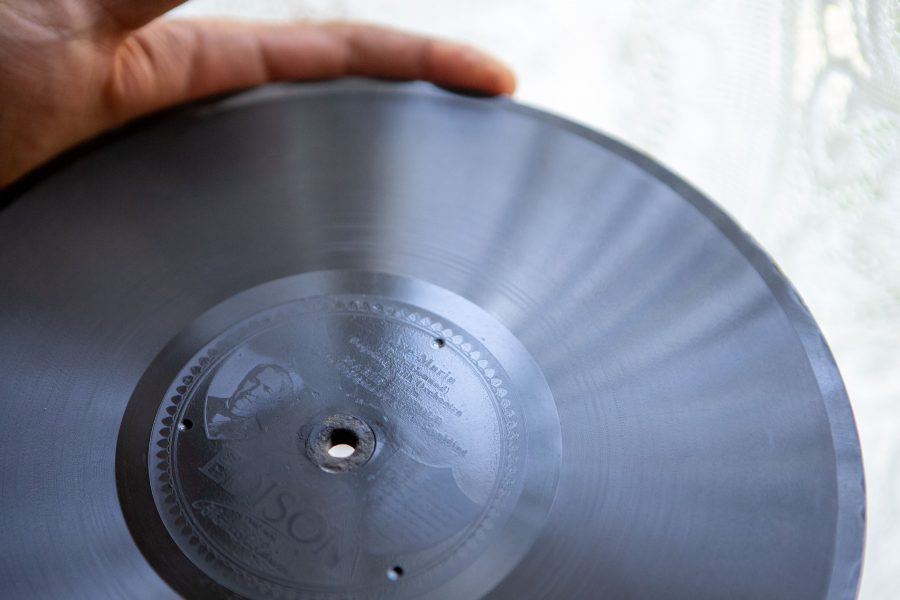 High school student and Avery House volunteer Blake Bergersen holds an old record that plays inside a 1920, Edison Diamond Disk record player inside the Avery House. The record  player is one of the many historic items found inside the nationally registered landmark. (Brooke Buchan | Collegian)