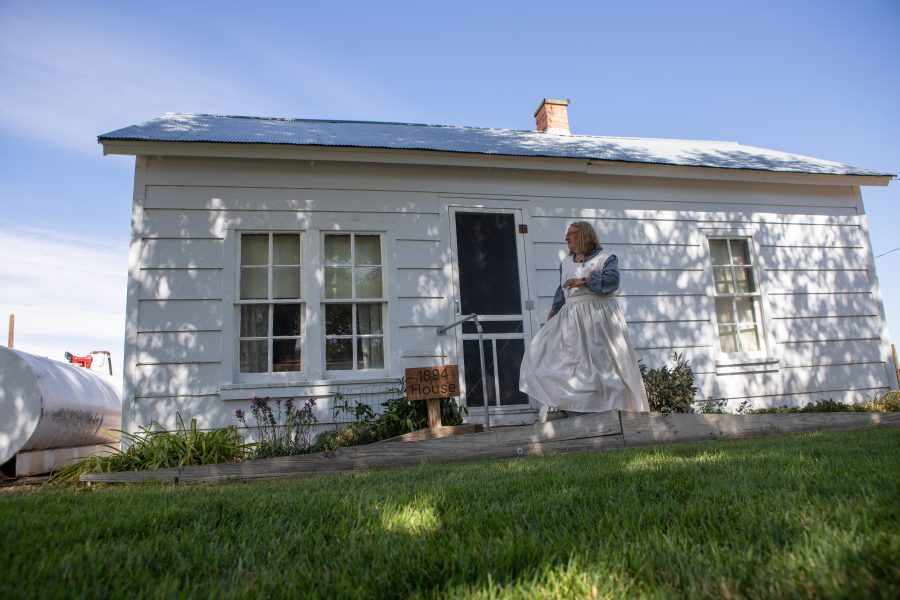 LeeAnn Bee, a volunteer at the Centennial Bee Farm and wife of Arthur Bee, stands in front of the well-preserved 1864 home. This is the original structure that the Bee family first settled and grew up in in Northern Colorado. (Brooke Buchan | Collegian)
