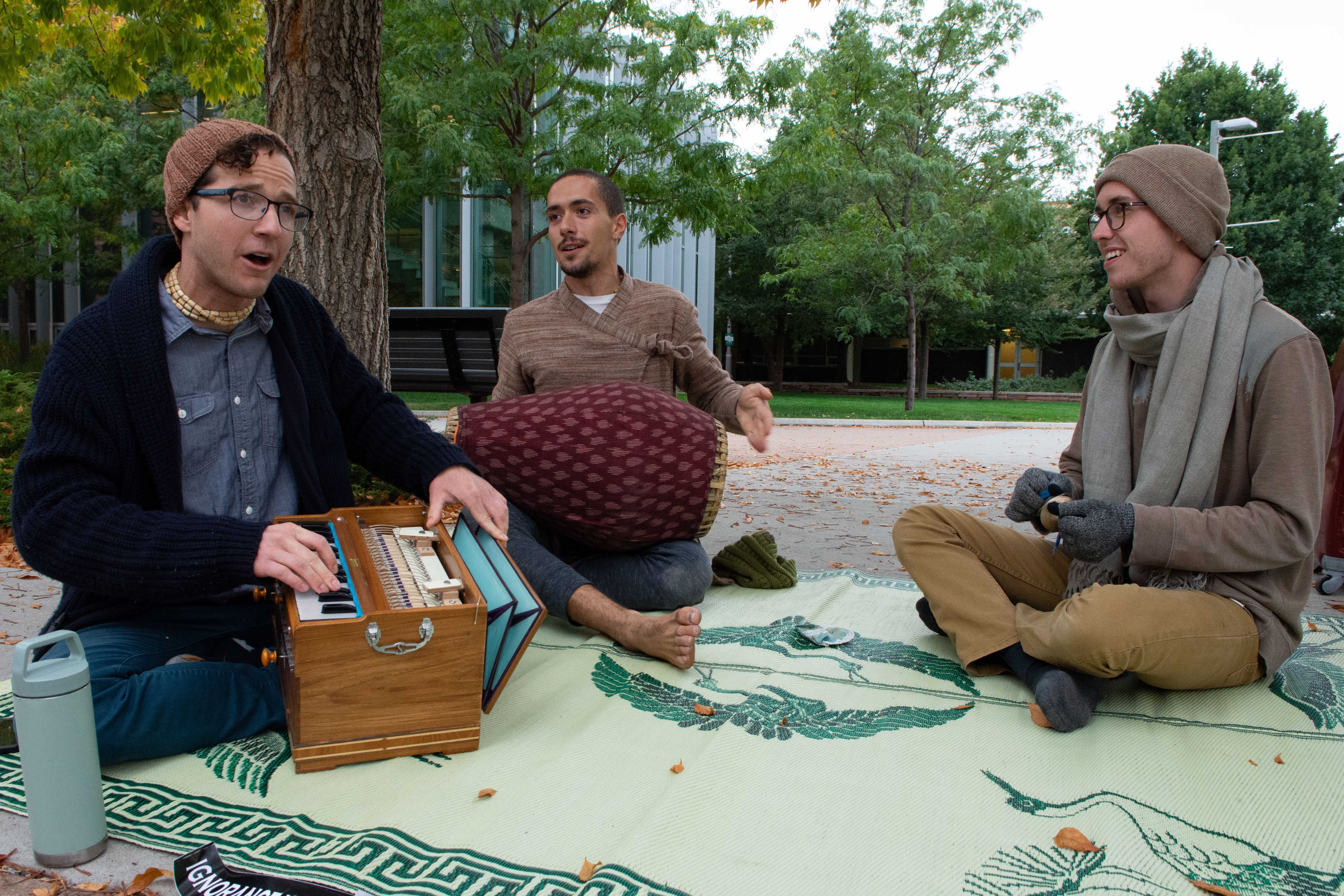 three men play instruments and sing