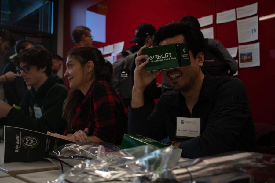 Ram Reality Hack-a-thon participant Ali Ebrahimpouru plays with items in goody bags given to participants and discusses the weekend game plan with his team, Oct 18. (Addie Kuettner | The Collegian)