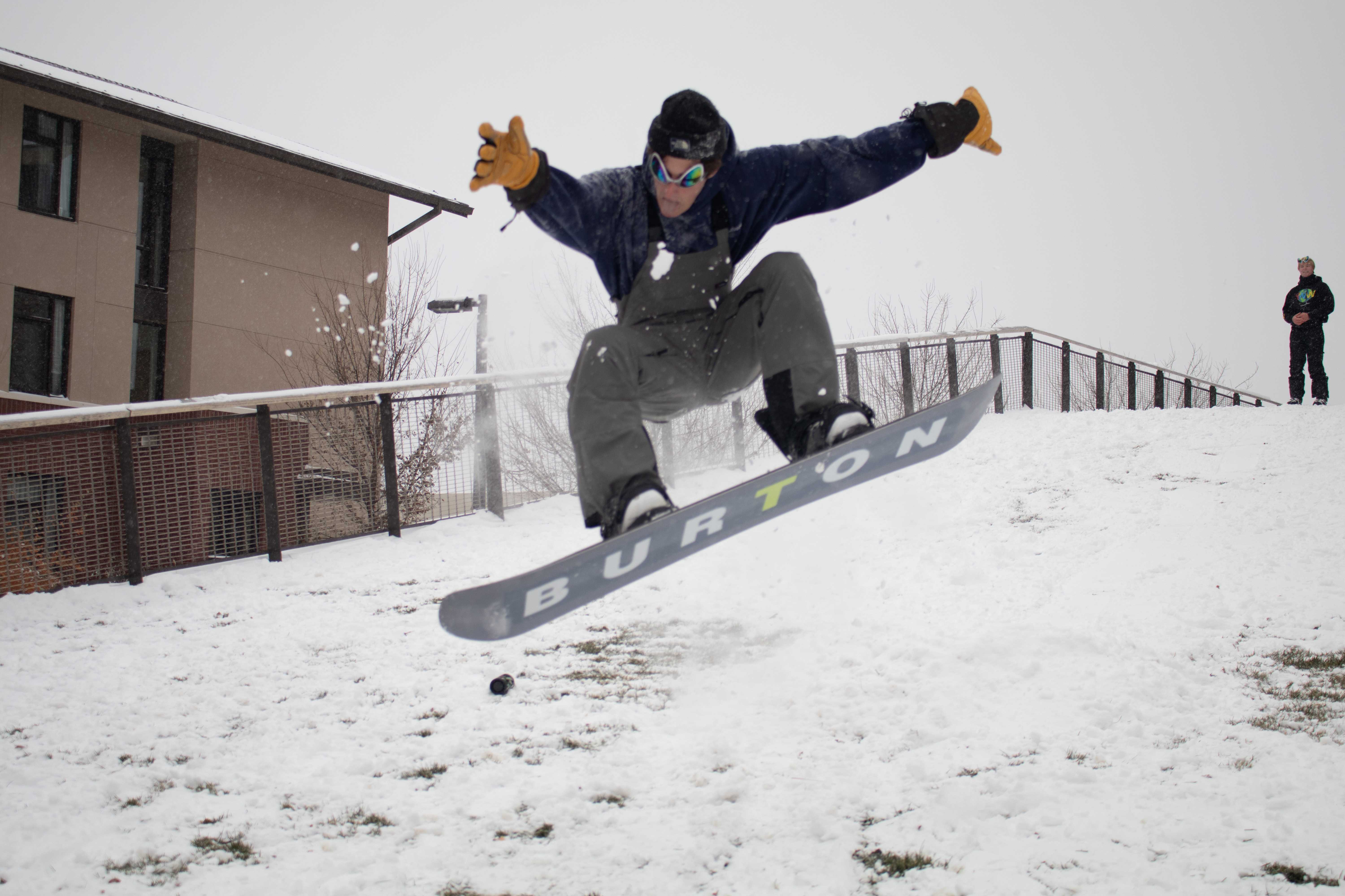 man snowboards