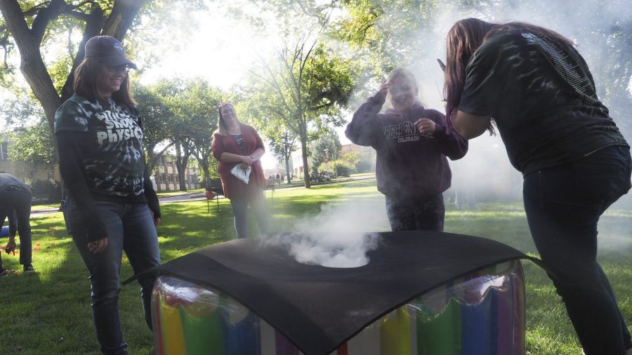 Little Shop of Physics club members Alexandra Smith and Elizabeth Hensley help Abby Vincent play with the ring of smoke machine at the Little Shop of Physics station. Brain Jones, professor of Physics at CSU and director of the Little Shop of Physics always enjoys these events. “The whole idea behind this is to get kids engaged and interested in science, and to make them want to learn more” Jones said. (Gregory James | Collegian)