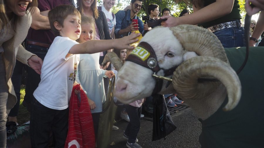 Fort Collins community members pet CAM the Ram at the homecoming parade on Oct. 4, 2019. (Gregory James | Collegian)
