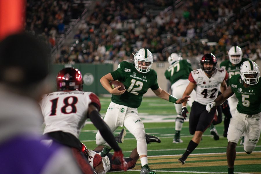 Patrick O'Brien(12) evades a tackle while running the ball, during the Colorado State homecoming game against San Diego State. CSU falls short 24-10. (Devin Cornelius | Collegian)