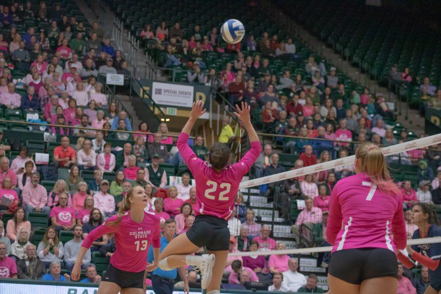 Katie Oleksak(22) sets the ball to her teammates during the Colorado State Pink Out game against Fresno State University. CSU wins three sets to zero.(Devin Cornelius | Collegian)