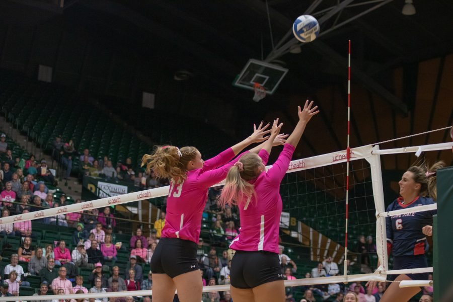 Kirstie Hillyer(13) and Sasha Colombo(7) jump and block an incoming spike from a Fresno State hitter, during Colorado State's home game against FSU. CSU wins three sets to zero. (Devin Cornelius | Collegian)
