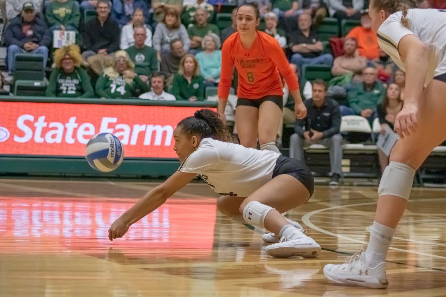 Brooke Hudson (4) digs down and bumps the ball into the air after a serve, during the University's home game against Air Force. CSU wins three sets to zero. (Devin Cornelius | Collegian)