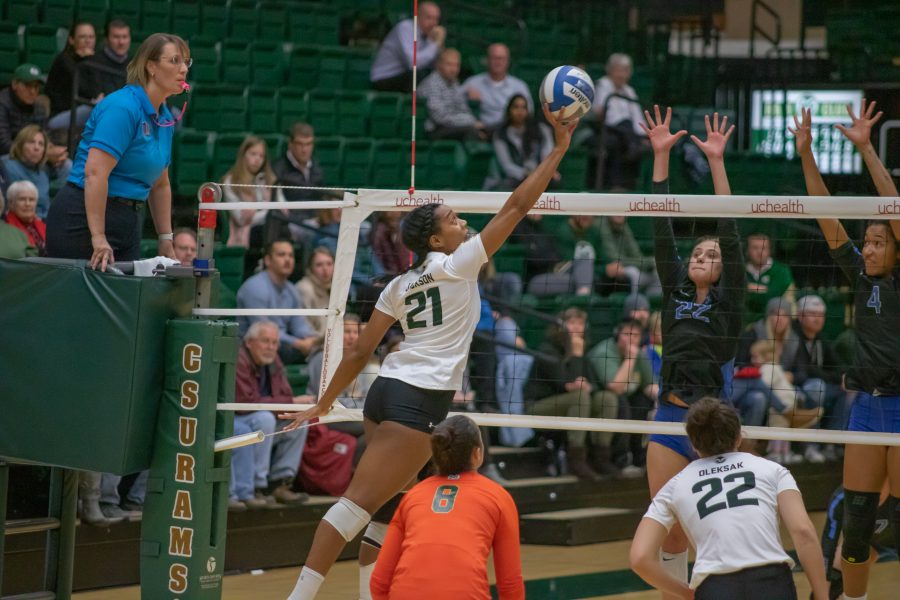 Jessica Jackson (21) tips the ball over the net, during the University's home game against Air Force. CSU wins three sets to zero.(Devin Cornelius | Collegian)